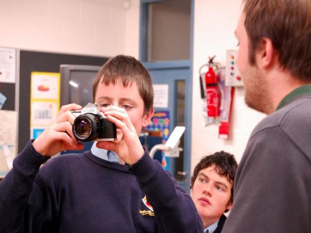 Student examining Camera Post Primary